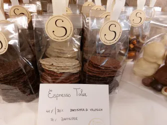 Schöne Schokoladentafeln in transparenten Verpackungen. Die Tafeln sind in verschiedenen Variationen von dunkler und milder Schokolade erhältlich.