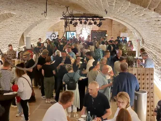 Ein belebter Veranstaltungsraum mit vielen Menschen, die sich unterhalten und feiern. Die Atmosphäre ist lebhaft und freundlich.