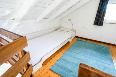 Der Schlafbereich ist mit 3 Einzelbetten ausgestattet. Paare nutzen gerne die beiden nebeneinander stehenden Einzelbetten, Alleinreisende das Einzelbett. Aufgrund der Dachschräge ist das Haus mit den Designklassikern "Stapelbett von Rolf Heide" ausgestattet, die mit einer Höhe von ca. 35 cm relativ tief sind.