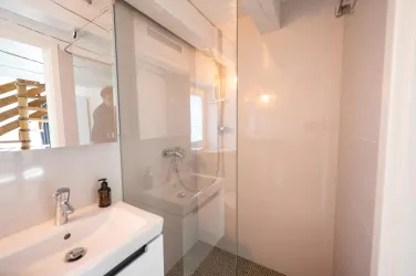 Ein modernes, kleines, funktionales Badezimmer mit einer offenen Dusche.