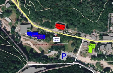 Eine Übersichtskarte mit verschiedenen Standorten und Beschriftungen. Die Karte zeigt Parks, Gebäude und Straßen in einem bewaldeten Gebiet.