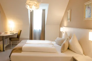 Ein modernes Zimmer mit einem Doppelbett und eleganter Einrichtung. Das Zimmer hat große Fenster und einen Schreibtisch.