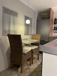 Essbereich mit Glastisch und Rattanstühlen
Minibar mit Pfälzer Weinen und kleine Schnapsbar