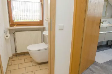 Bad mit Toil., Dusche, WC (re) + Gästetoil. (li)