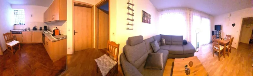 Eine gemütliche Wohnküche mit modernen Möbeln und einem hellen Wohnzimmer. Der Raum ist gut beleuchtet und einladend.