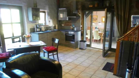 Eine gemütliche Küche mit moderner Ausstattung und einem Essbereich. Das Wohnzimmer ist hell und einladend mit bequemen Möbeln.