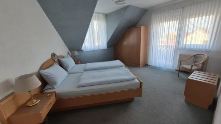 Gemütliches Schlafzimmer mit einem Doppelbett und Schrank aus Buchenholz, Große Fenster und einer Terrassentür die direkt zum großem Balkon führt. Von der Morgensonne verwöhnt werden.