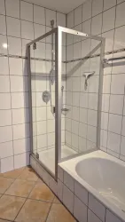 Ein modernes Badezimmer mit einer Glasduschkabine und einer Badewanne.