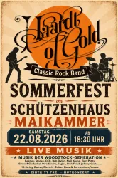 Ein Mann mit grauen Haaren steht mit einer Gitarre im Hintergrund. Er hat einen nachdenklichen Ausdruck und trägt ein einfaches schwarzes Oberteil.