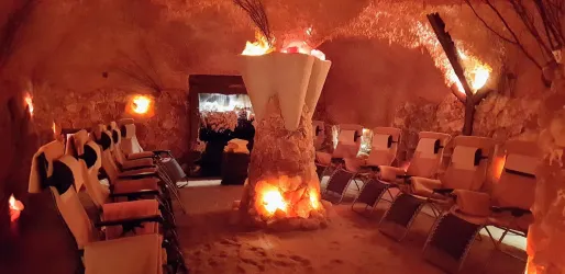 Ein entspannender Ruheraum, umgeben von Salzsteinen und sanfter Beleuchtung. Komfortable Liegen laden zur Erholung ein.