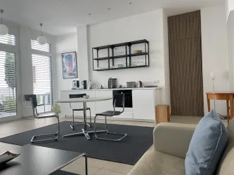 Die moderne, helle Wohnung mit einer offenen Küche und einem gemütlichen Wohnbereich ist sehr ruhig und dank der  großen Fenstern sehr hell. Die hochwertige Einrichtung besticht durch ihren Bauhausstil.