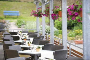 Unsere überdachte Terrasse mit Tisch und Stühlen, direkt am Garten.