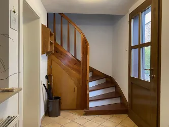 Ein einladender Flur mit Holztreppe zum 1. Obergeschoss.