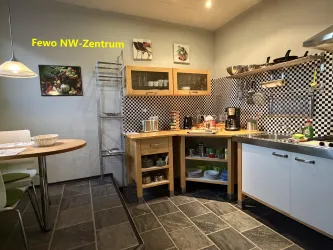 Eine moderne Küche mit checkered Wänden und Holzregalen. Es gibt einen Esstisch und ausreichend Platz für Kochutensilien.