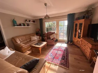 Das gemütlich eingerichtete Wohnzimmer mit TV bietet ausreichen Platz und einen schönen Blick ins Grüne.