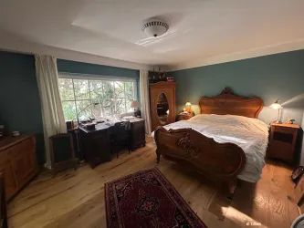 Das Hauptschlafzimmer mit seiner einzigartigen nostalgischen Einrichtung bietet ebenfalls viel Platz und einen Ausblick ins Grüne.