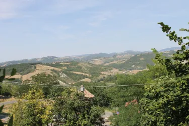 Eine malerische Landschaft mit sanften Hügeln und üppigem Grün. Der Himmel ist klar und das Panorama erstreckt sich weit ins Land.