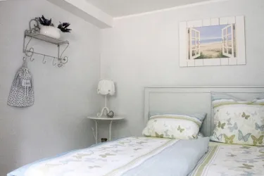 Ein helles Schlafzimmer mit einem Doppelbett 160 cm x 200 cm ohne Fußteil.