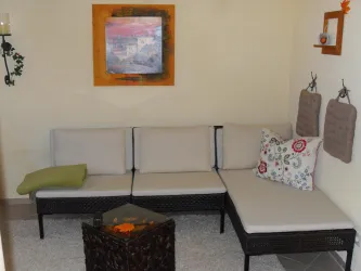 Eine moderne Sitzecke mit einem hellen Sofa und einem kleinen Tisch in der Mitte.