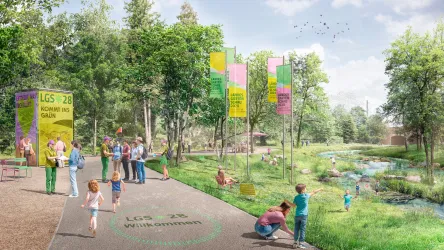Eine grüne Landschaft mit Menschen, die sich auf einem Weg und am Wasser entspannen. Bunte Schilder und Bäume verleihen dem Ort ein einladendes Ambiente.