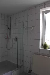 Badezimmer mit Dusche und Fenster