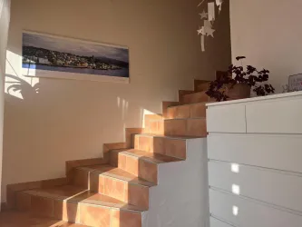 Eine helle Treppe führt nach oben in die Ferienwohnung.