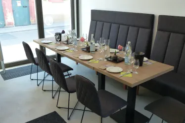 Ein gedeckter Tisch für eine Weinprobe in der Vinothek. Die Umgebung ist hell und einladend, mit Platz für mehrere Gäste.