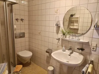 Zimmer 4 hat ein eigenes Duschbad mit WC und Waschbecken.