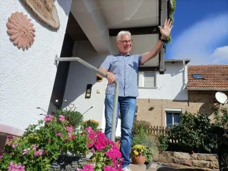 Inhaber Matthias Ehmer heißt Gäste am Eingang des Gästehauses an der Weinstraßenmitte in Neustadt-Diedesfeld herzlich willkommen.