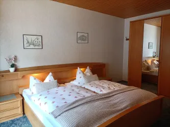 Zimmer 3 bietet ein großes Doppelbett und einen Kleiderschrank mit Spiegeltür.