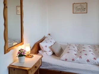 Das Einzelbett in Zimmer 1 mit warmer Nachttischbeleuchtung – ideal für Alleinreisende, Wanderer und Radfahrer an der Deutschen Weinstraße.