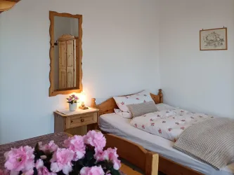 Zimmer 1 ist ein gemütliches Einzelzimmer im Gästehaus an der Weinstraßenmitte in Neustadt-Diedesfeld – mit Einzelbett, Möbeln aus hellem Holz und Balkonzugang.
