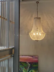 Ein eleganter Kronleuchter aus Kristall hängt an der Decke. Im Hintergrund ist ein farbenfrohes Gemälde zu sehen.