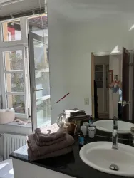 Helles lichtdurchflutes Badezimmer mit einem großen Fenster.