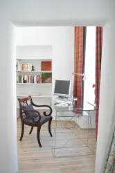 Ein modernes Arbeitszimmer mit einem gläsernen Schreibtisch.