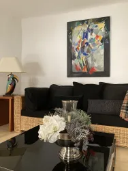 Ein gemütliches Sofa lädt zum Lesen, Chillen und Fernsehen ein. Es kann auch als weitere Schlafmöglichkeit genutzt werden. Zwei Sessel runden die Sitzecke ab. Der Fernsehapparat steht auf einem Sideboard, in dem Gesellschaftsspiele zur Verfügung stehen.