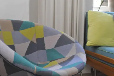 Ein moderner, farbenfroher Sessel mit geometrischem Muster. Stoff von Patricia Guild.
