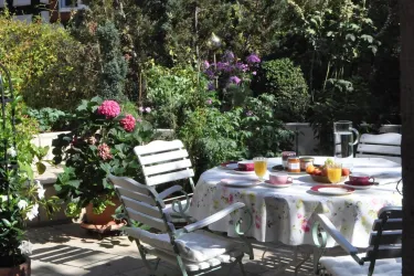 Mediterane Terrasse mit Sitzmöglichkeiten für 6 Personen, Liegestühle, Grill und einem kleinen Fischbecken.