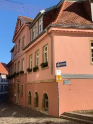 Ehemaliges Schul- und Rathaus in exponierter Lage am Jakobusplatz von 1724. Zweigeschossiger winkelförmiger Bau des Klassizismus. Nach Brand 1909 Aufstockung mit Mansardendach im Heimatstil. Die traufseitige Fassade mit übergiebeltem  Mittelrisalit von 3 Achsen und drei Geschossen. Dachüberstände mit Kassettierung.