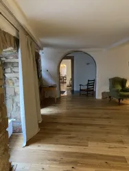 Ein heller Flur mit Holzboden und einem Rundbogen. Im Hintergrund ist das Esszimmer zu sehen.