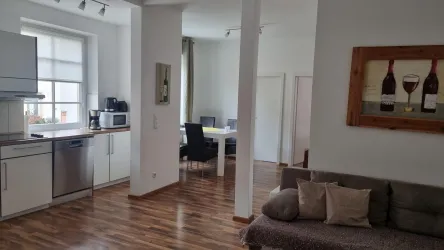 Eine moderne Wohnung mit offenen Räumen. Die Küche ist gut ausgestattet und ein komfortables Sofa lädt zum Entspannen ein.