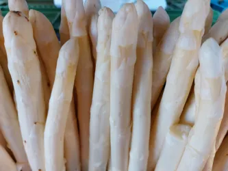 Frische, weiße Spargelstangen stehen dicht beieinander. Sie wirken knackig und appetitlich.