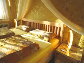Ein gemütliches Schlafzimmer mit einem Holzbett und weichen Kissen. Das sanfte Licht und die dekorative Wand vermitteln eine einladende Atmosphäre.