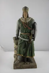 Eine Statue von Rudolf von Habsburg in grüner Kleidung. Er hält ein Schwert und steht auf einem Felsen.