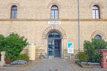 Ein historisches Gebäude mit der Beschriftung „Zeughhaus“ über dem Eingang. Vor dem Eingang stehen Pflanzen und Fahrräder.