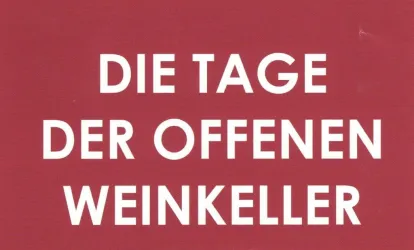 Ein rotes Schild mit der Aufschrift „Die Tage der offenen Weinkeller“. Es kündigt einen Event an, bei dem Weinkeller besichtigt werden können.