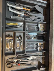 Eine gut organisierte Besteckschublade mit verschiedenen Utensilien. Sie enthält Gabeln, Messer, Löffel und Küchenwerkzeuge.