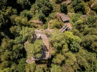 Ein Blick auf zwei Plattformen, die von Bäumen umgeben sind. Die Strukturen sind auf Felsen errichtet und bieten eine schöne Aussicht in die grüne Landschaft.