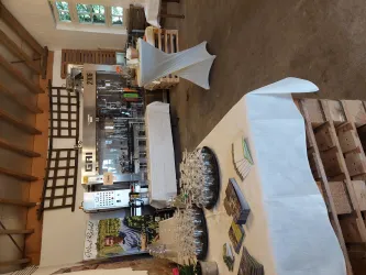 Ein eleganter Innenraum mit Tischen und Glaswaren. Im Hintergrund befindet sich eine Bar mit Getränken und Dekoration.