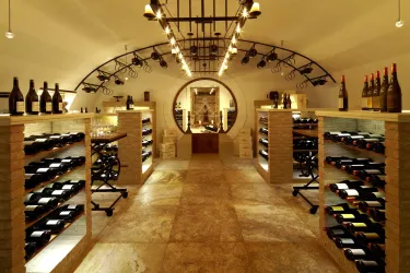 Ein eleganter Weinkeller mit Regalen voller Weinflaschen. Sanfte Beleuchtung schafft eine einladende Atmosphäre.
